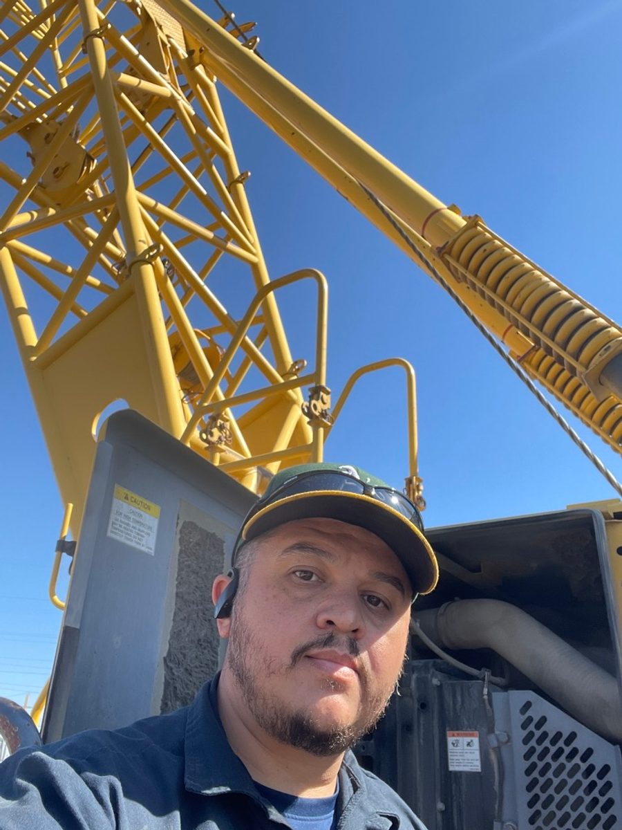 Daniel, founder of Mechanix Onsite, on a job site in front of a crane